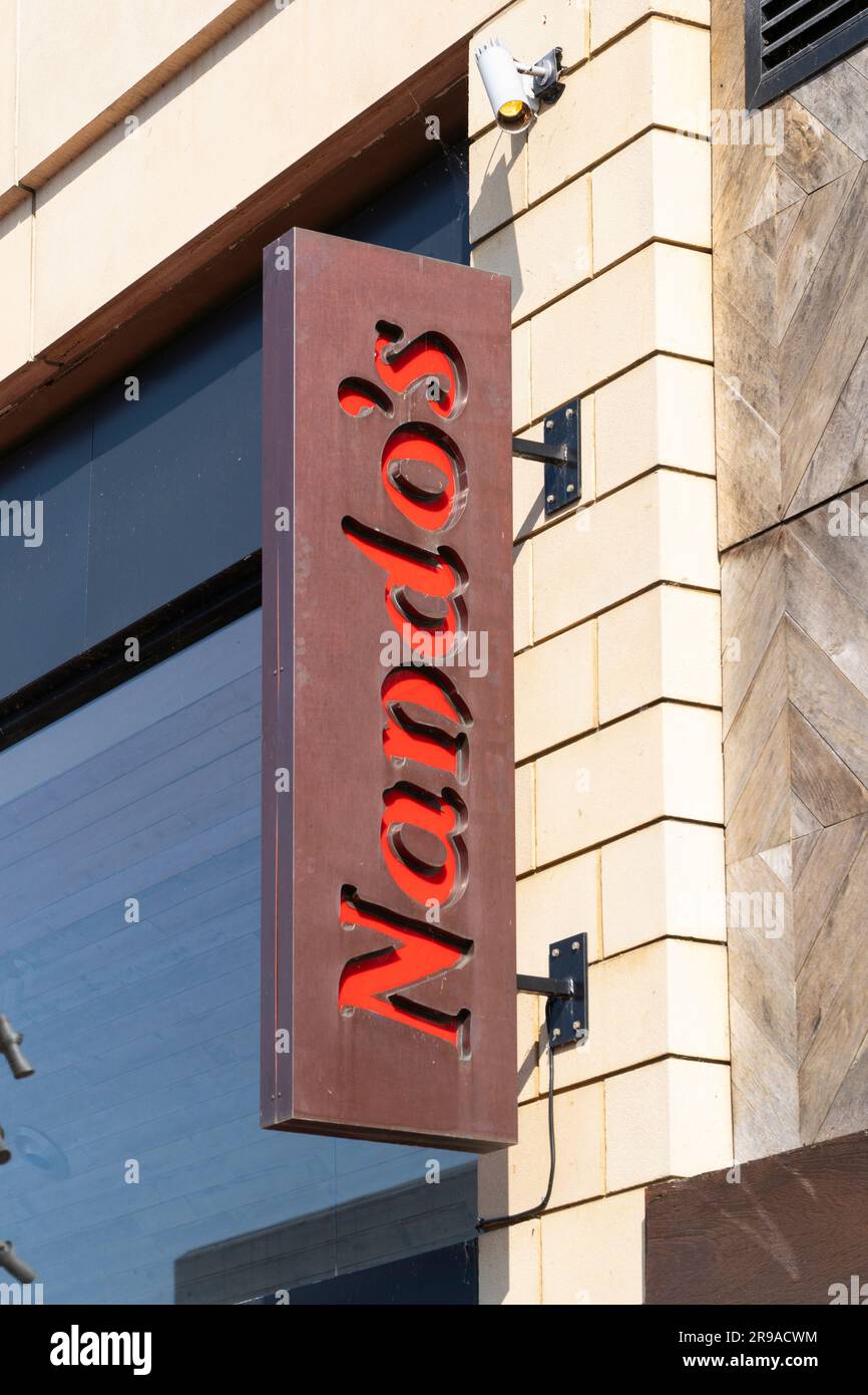 Affiche et logo lettrage pour le restaurant Nandos, une chaîne afro-portugaise servant du poulet grillé sur l'Oracle Center Riverside à Reading, Royaume-Uni Banque D'Images