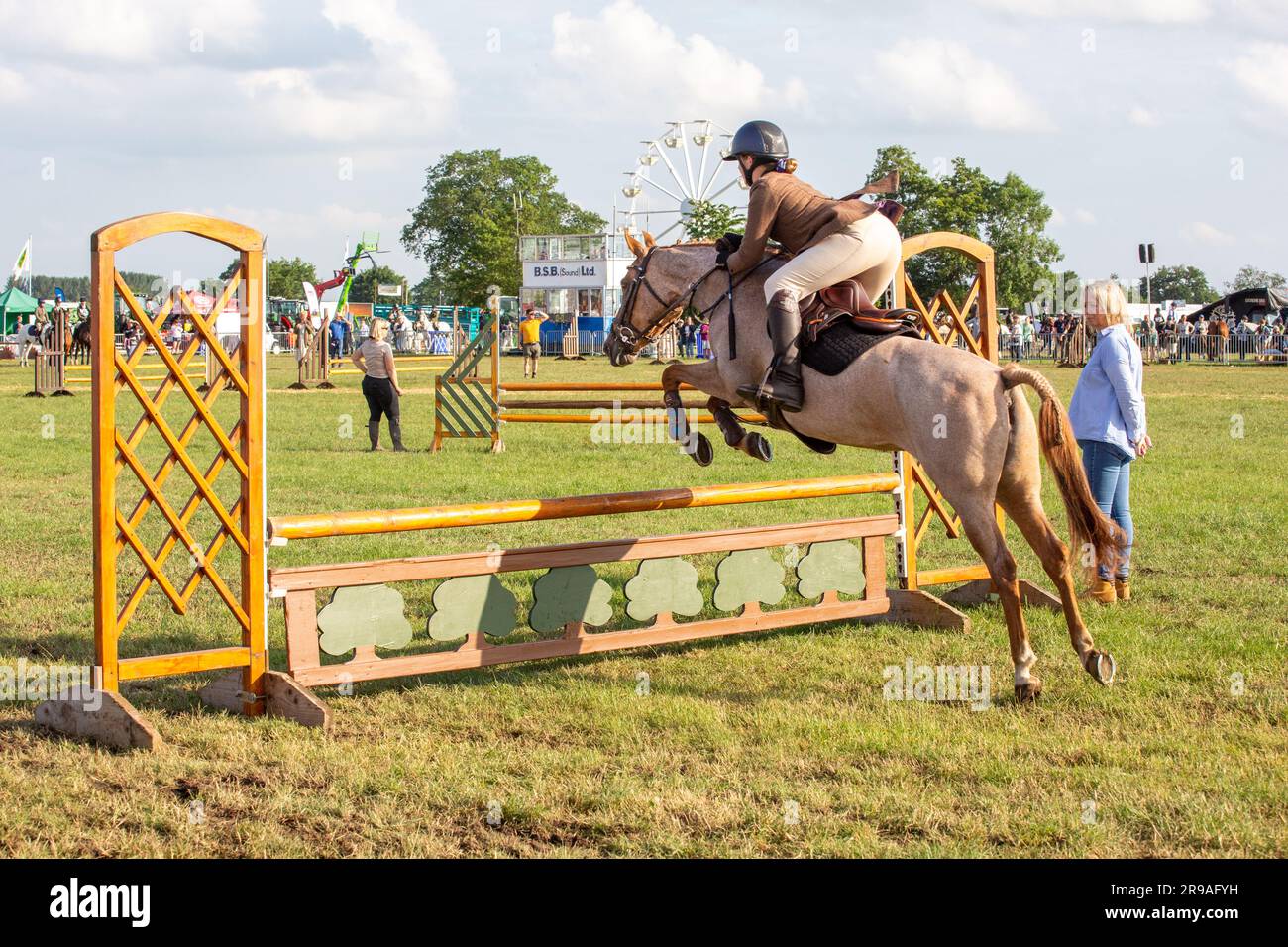 Un cheval et un cavalier sautant une clôture dans la classe de chasseurs en activité lors du spectacle agricole Royal Cheshire du 2023 juin au champ d'exposition de Tabley Banque D'Images