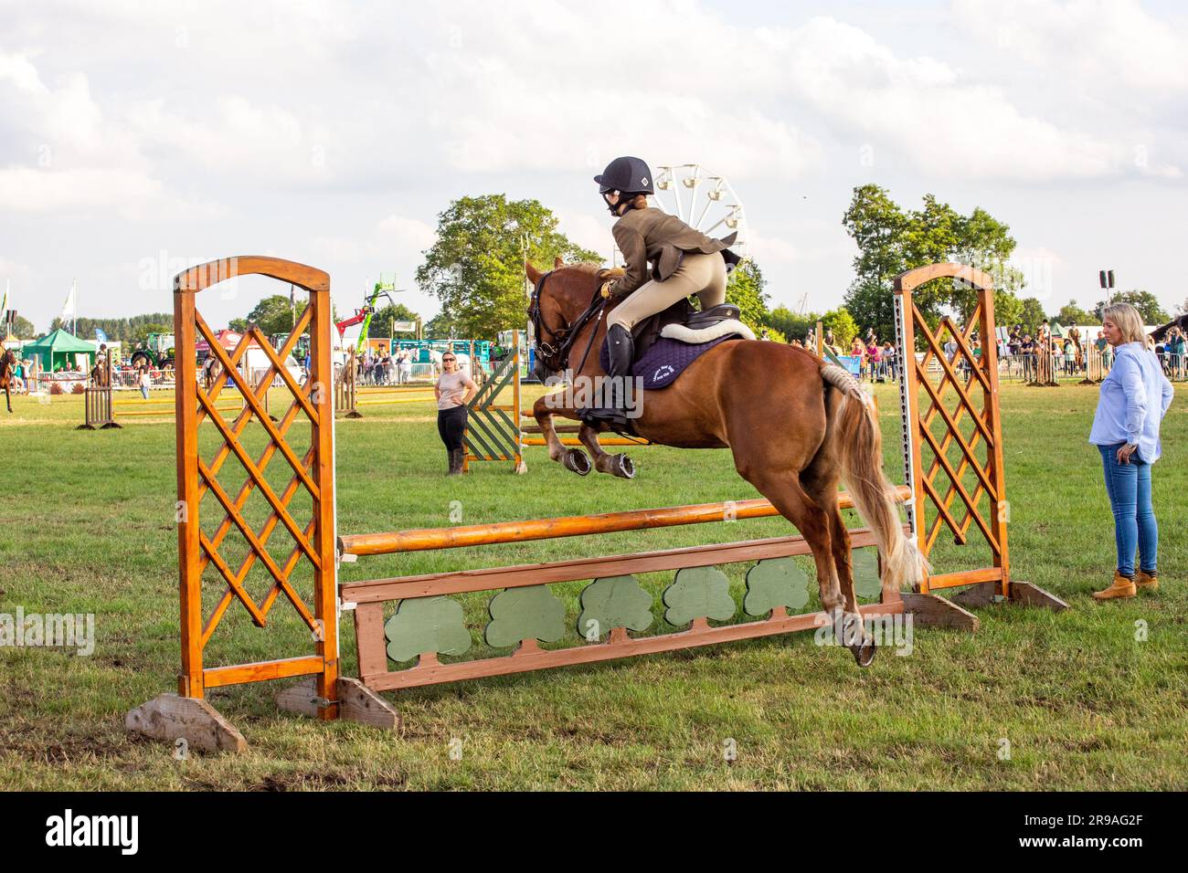 Un cheval et un cavalier sautant une clôture dans la classe de chasseurs en activité lors du spectacle agricole Royal Cheshire du 2023 juin au champ d'exposition de Tabley Banque D'Images