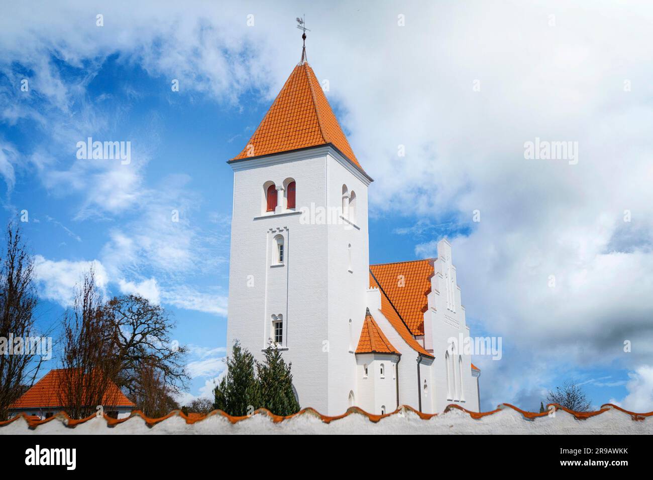 Église blanche en conception nordique derrière un mur avec un beau ciel au-dessus Banque D'Images