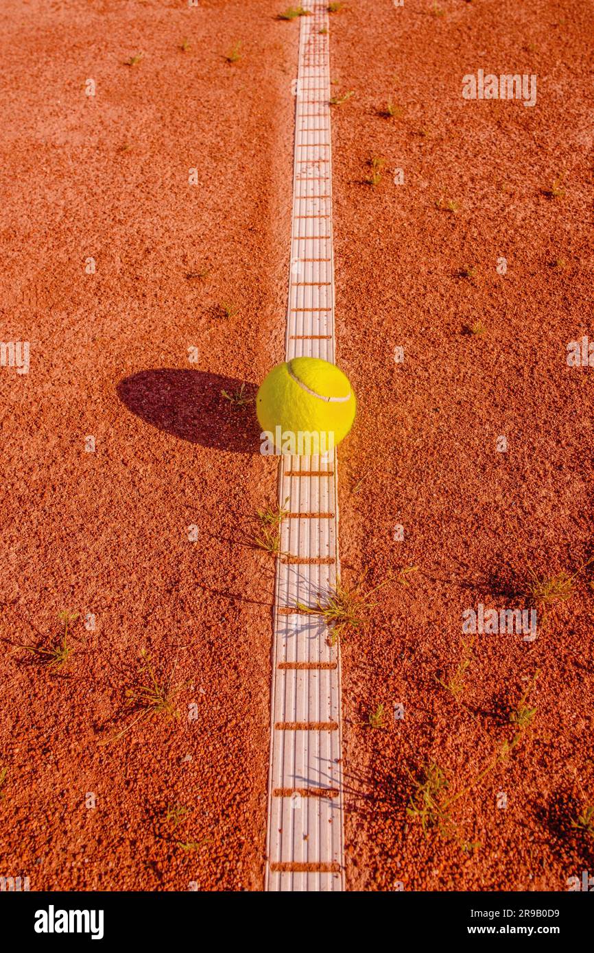 Tennisball jaune sur une cour ancienne et abîmée Banque D'Images