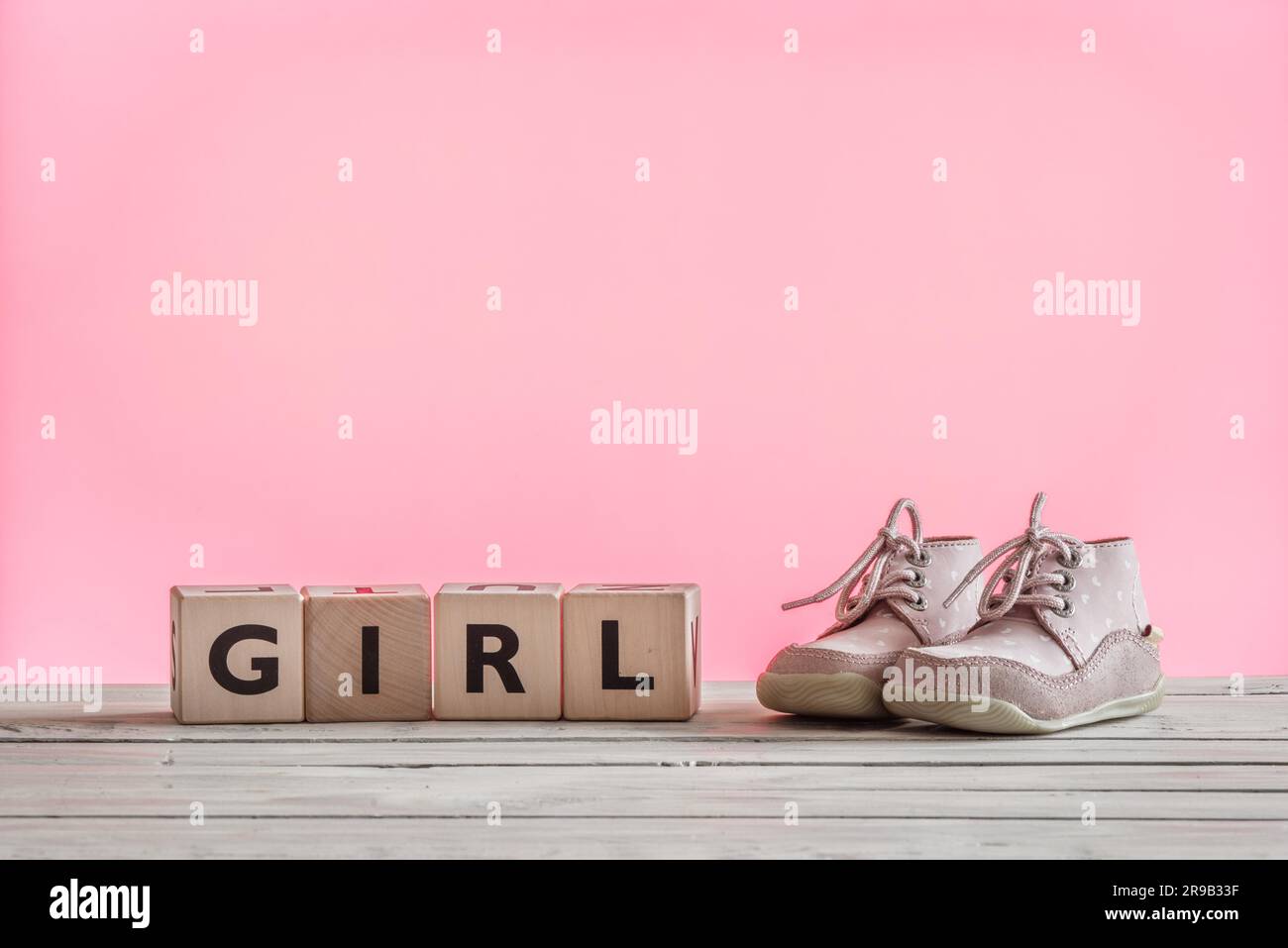 Chaussures bébé fille en rose sur une table en bois Banque D'Images