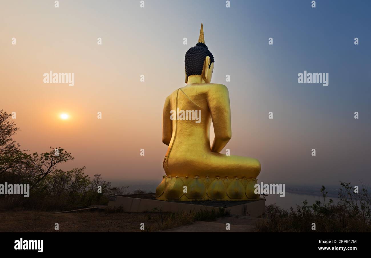 Bouddha doré surplombant Paksé au coucher du soleil. Wat Phousalao. Laos Banque D'Images
