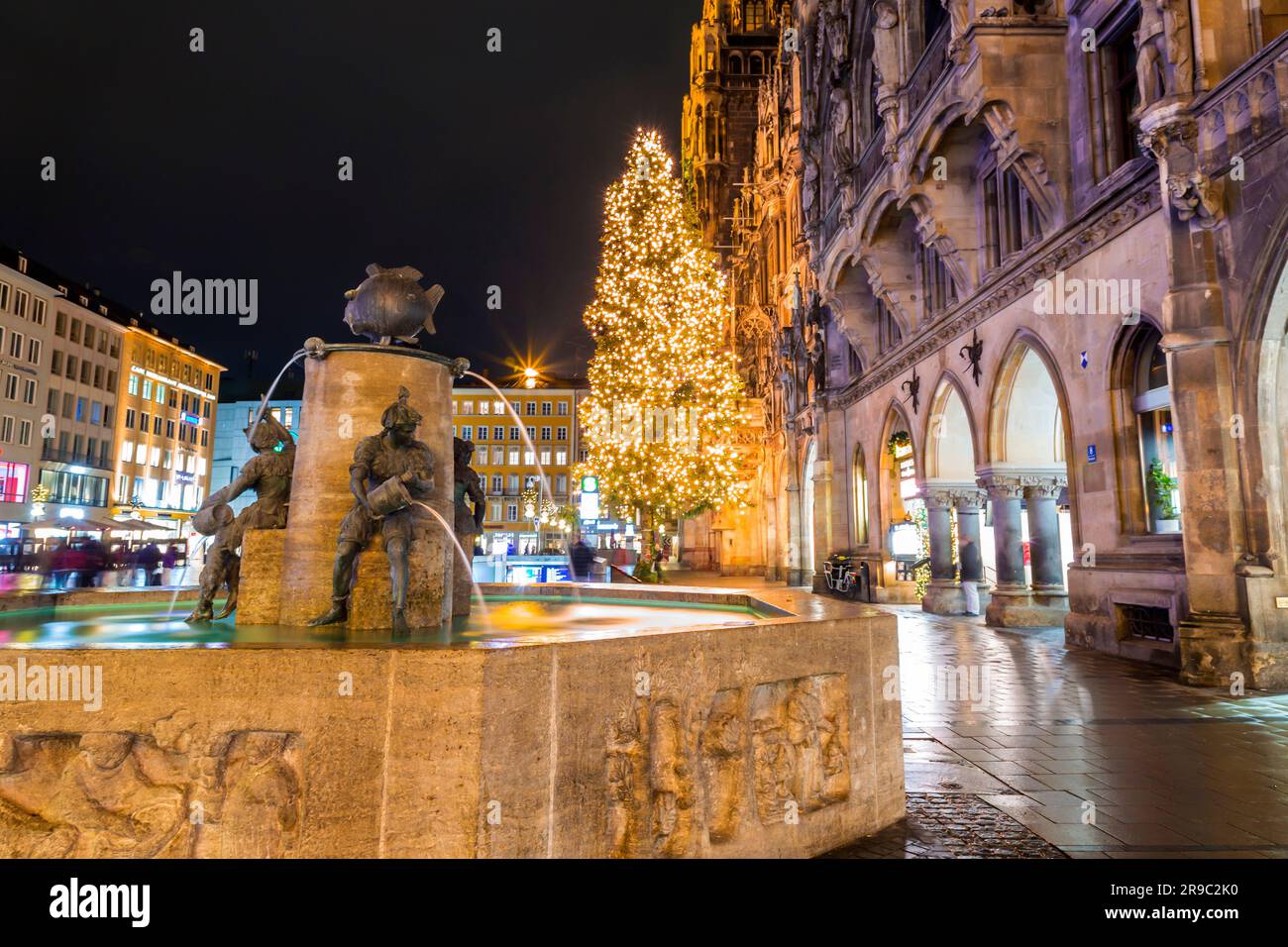 Munich, Allemagne - 23 décembre 2021: Fischbrunnen (fontaine de poissons) et la Neue Rathaus de Munich (nouvel hôtel de ville) à Marienplatz, la place de la ville en hi Banque D'Images