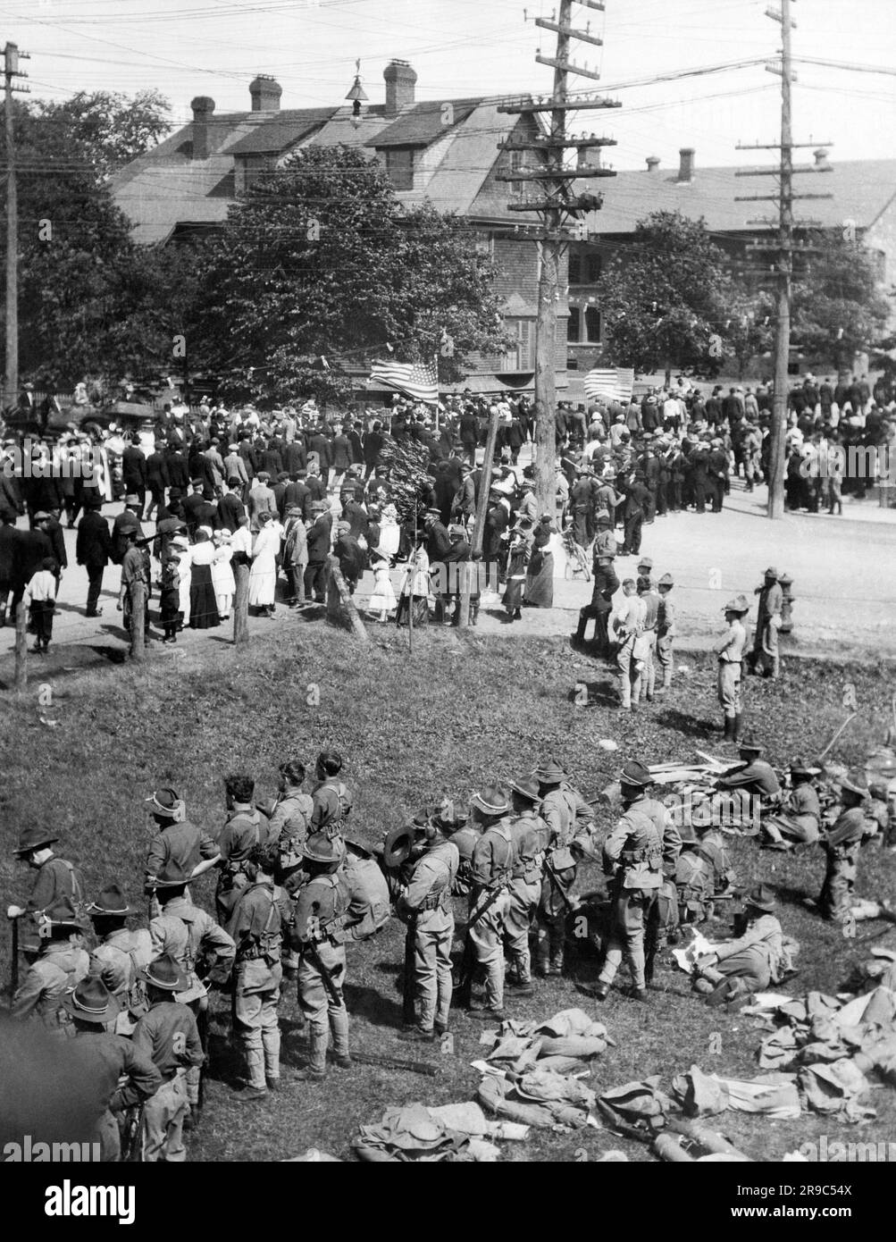 Calumet, Michigan: 1913 Une parade de mineurs de cuivre en grève passant devant les offvices de la compagnie minière Calumet et Hecla, tandis que les troupes de la Garde nationale restent à côté en cas de problème. Banque D'Images