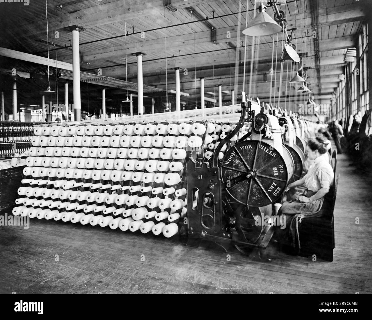 Boston, Massachusetts: 1912 femmes travaillant à des machines d'inspection de fils et de beaming à l'American Woolen Company. Banque D'Images