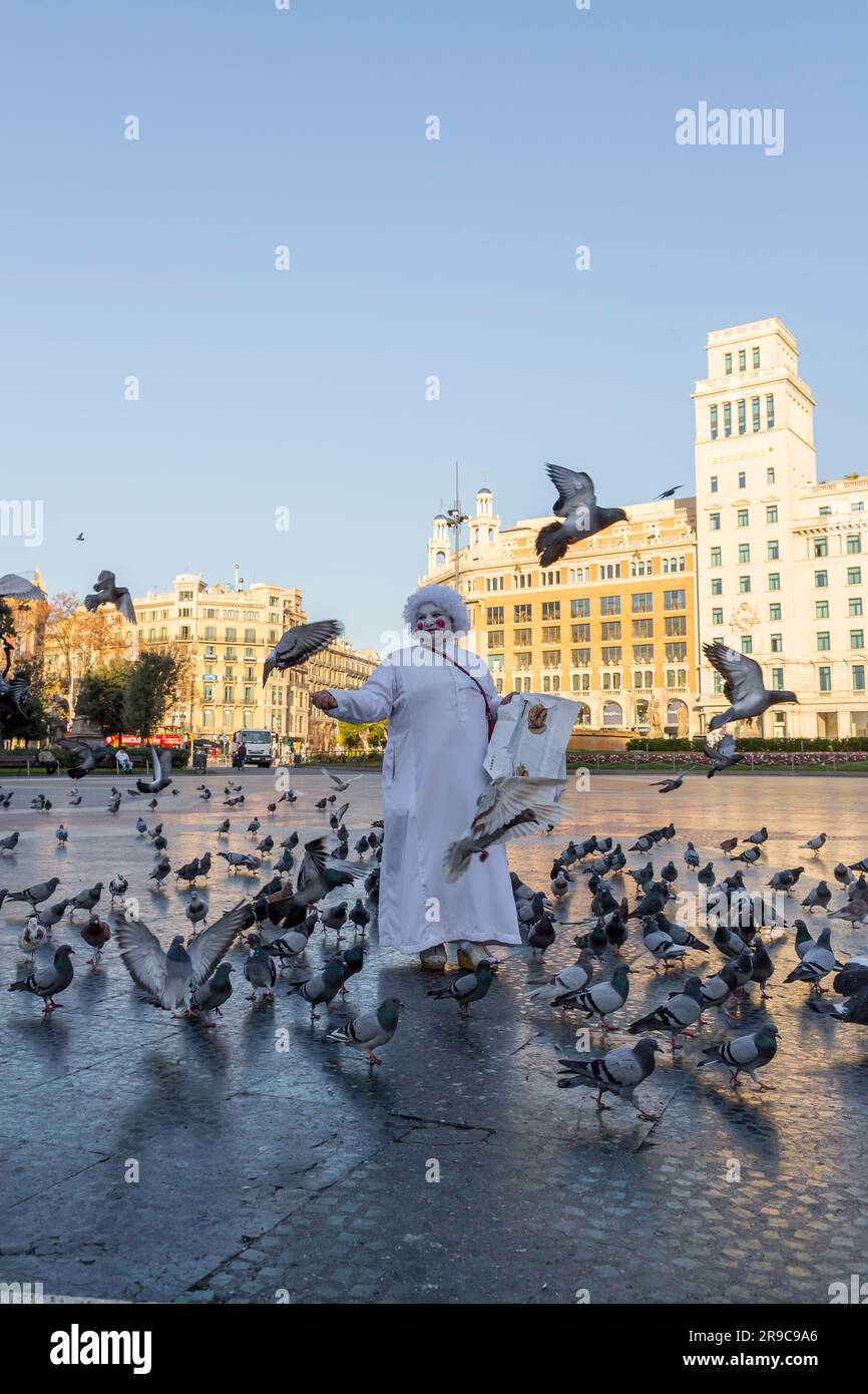 Barcelone, Espagne - 10 février 2022: Femme senior en maquillage blanc et costume vendant du riz pour nourrir les pigeons à la place de Catalogne à Barcelone, S Banque D'Images