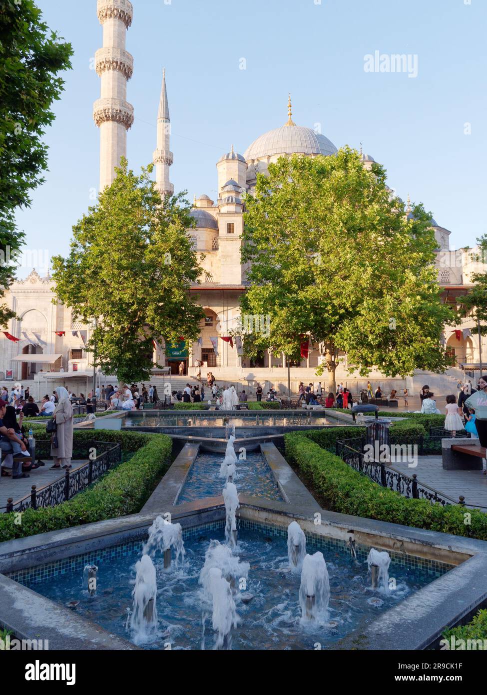 Extérieur de la mosquée Yeni Cami un jour d'été avec un ciel bleu vu des fontaines sur la place publique, Istanbul, Turquie Banque D'Images