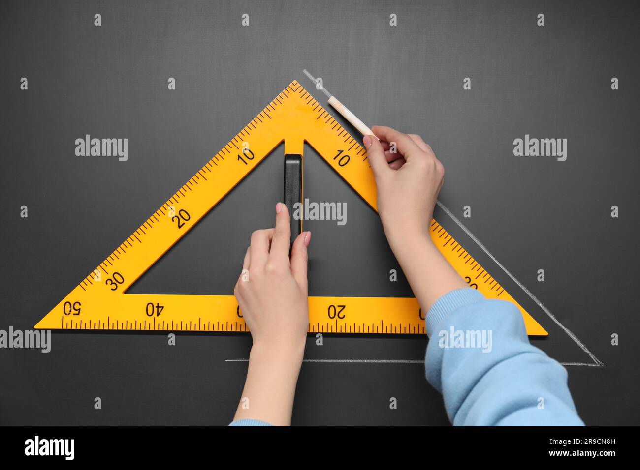 Femme dessin avec craie et règle triangulaire sur tableau noir, gros plan Banque D'Images