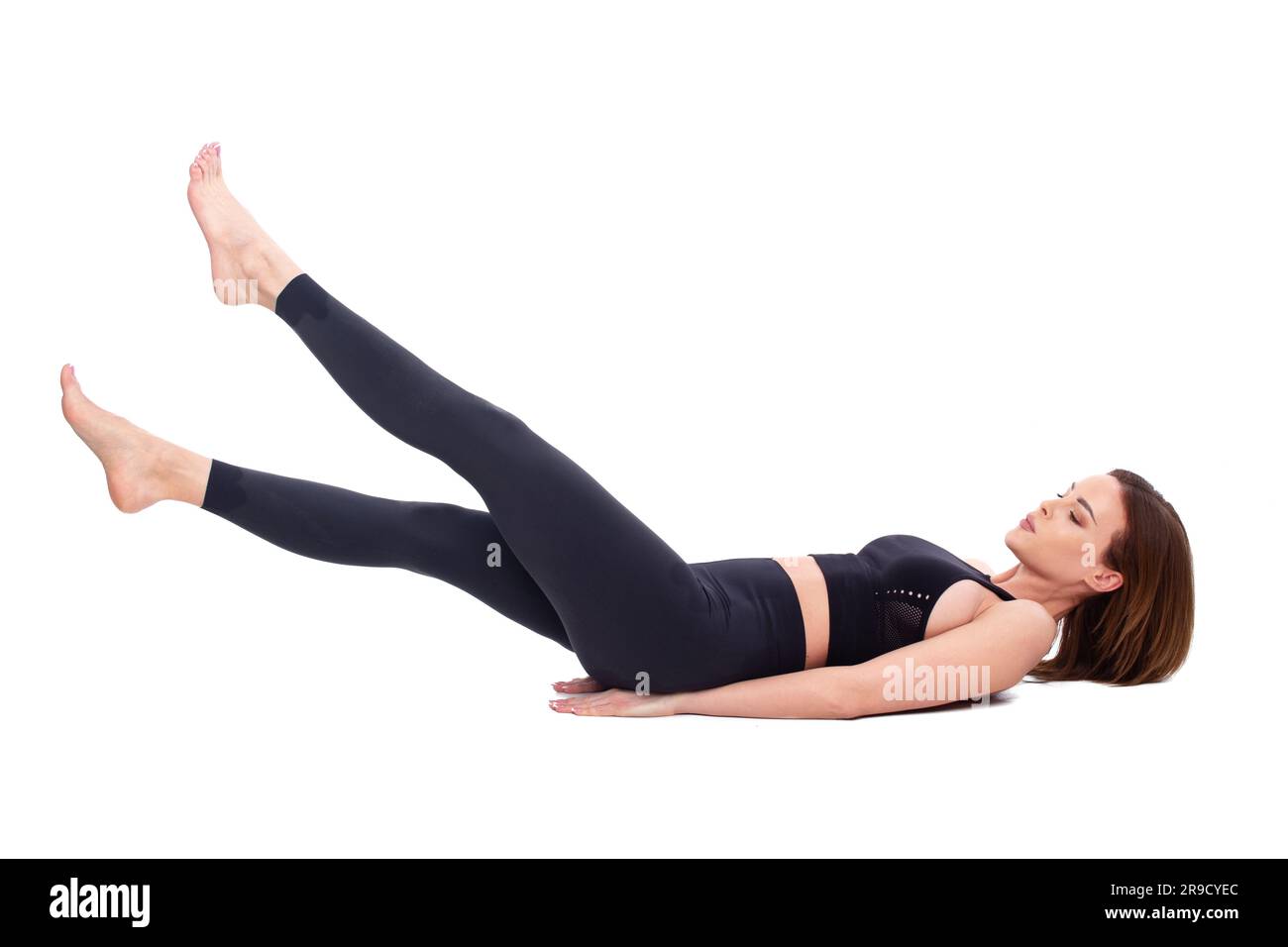 30s Femme de forme caucasienne faisant des coups de pied flutter exercice dans les vêtements de sport, isolé sur la couleur blanche Banque D'Images