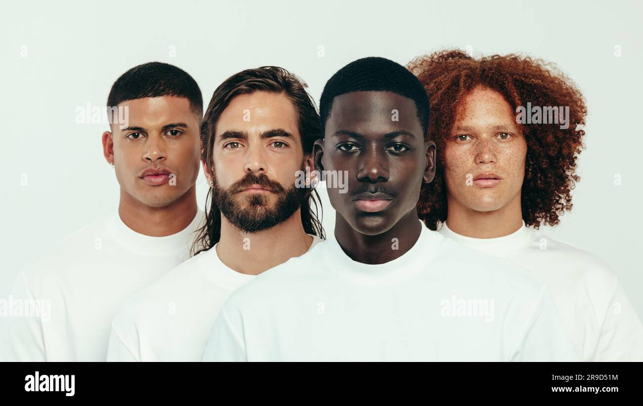 Portrait d'un groupe d'hommes avec des tons chair uniques debout dans un studio, regardant l'appareil photo en toute confiance. Quatre jeunes hommes embrassant la diversité et un li Banque D'Images Portrait d'un groupe d'hommes avec des tons chair uniques debout dans un studio, regardant l'appareil photo en toute confiance. Quatre jeunes hommes embrassant la diversité et un li Banque D'Images