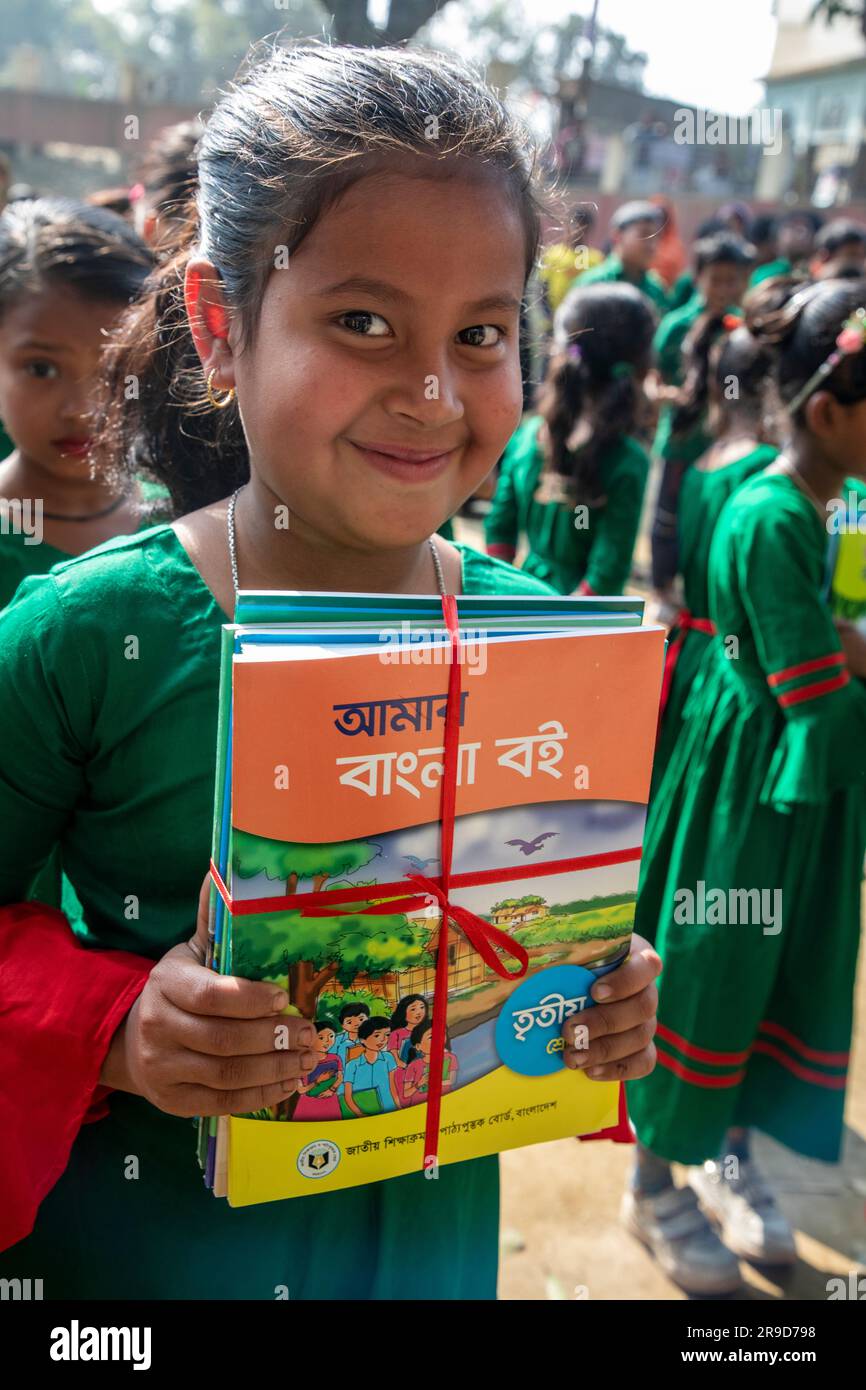 Les élèves de l'école primaire bangladaise tiennent de nouveaux manuels après les avoir reçus pour les nouvelles classes de Singair à Manikganj. Bangladesh. Le gouvernement di Banque D'Images