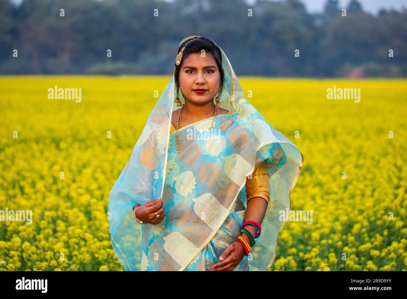 Une femme bangladaise nouvellement mariée à l'intérieur d'un champ de moutarde à Singair à Manikganj, au Bangladesh. Banque D'Images