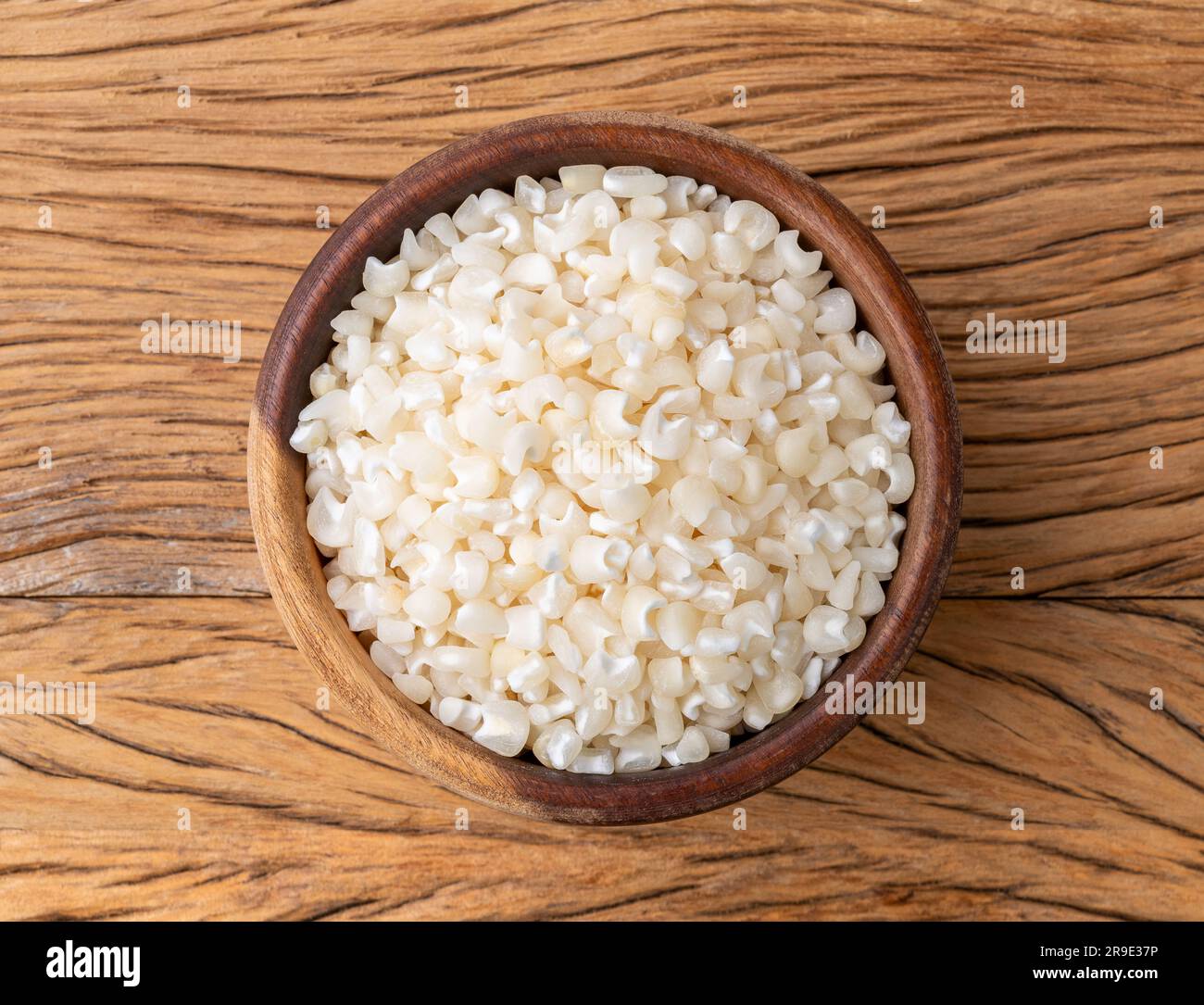 Canjica séché, maïs hominy ou blanc sur un bol sur une table en bois. Banque D'Images