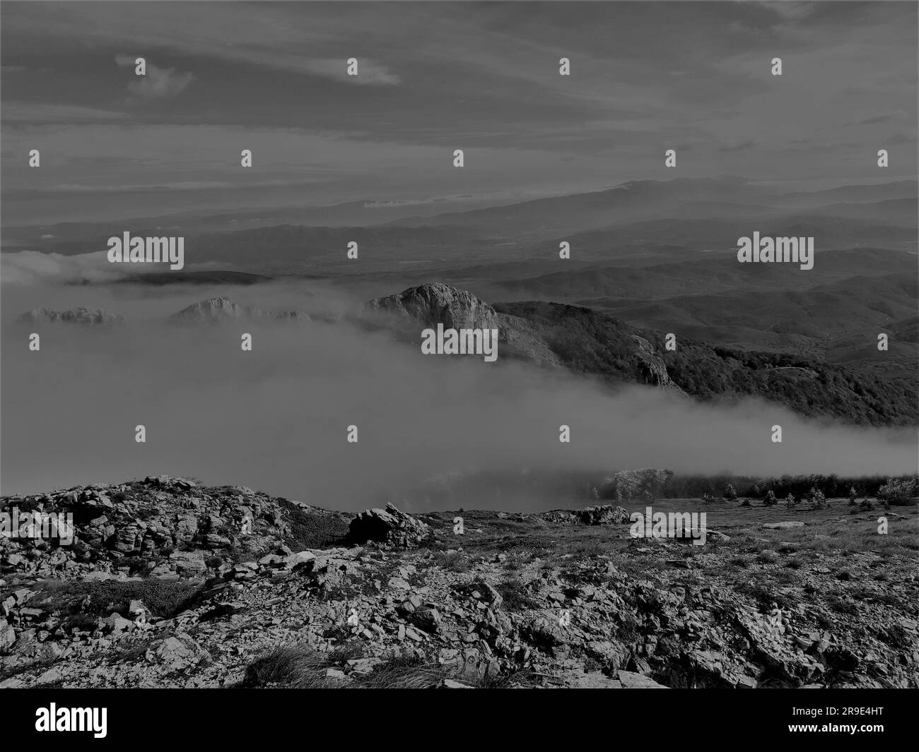 Un cliché noir et blanc d'une chaîne de montagnes couverte de nuages Banque D'Images