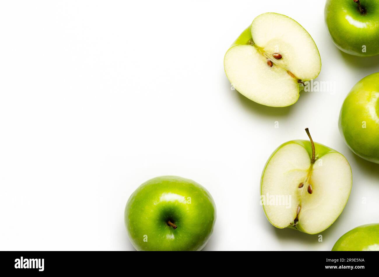 Pommes entières vertes et tranchées sur fond blanc avec espace de copie. Banque D'Images