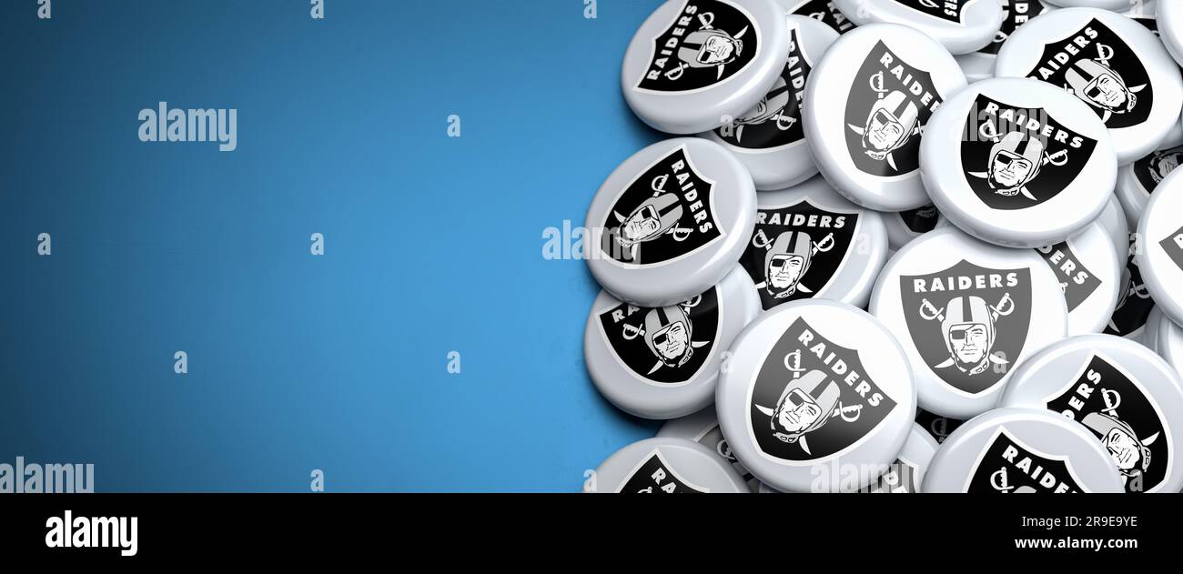 Logos de l'équipe américaine de football Oakland Raiders sur un tas sur une table. Banque D'Images