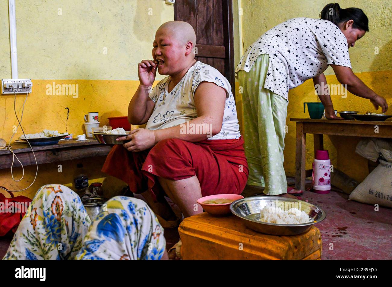 Churachandpur, Inde. 21st juin 2023. Le malade du cancer Chinkhothang Baite (L) mange un déjeuner dans un camp de secours dans le village de Rengkia. Au 3 mai 2023, un conflit ethnique a éclaté dans l'État indien du Manipur, dans le nord-est du pays, entre le peuple Meitei, dont une majorité vit dans la vallée de l'Imphal, et les communautés tribales dans les montagnes environnantes, y compris les Kuki et Zo. Au moins 109 personnes ont perdu la vie et plus de 300 ont été blessées dans des violences à caractère ethnique entre le Meitei et le Kuki dans l'État indien de Manipur. Crédit : SOPA Images Limited/Alamy Live News Banque D'Images