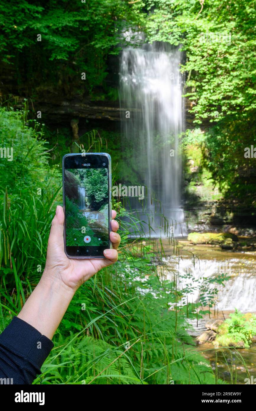 Prendre une photo d'un point de repère sur un téléphone portable, Glencar Waterfall, Comté de Sligo, Irlande Banque D'Images