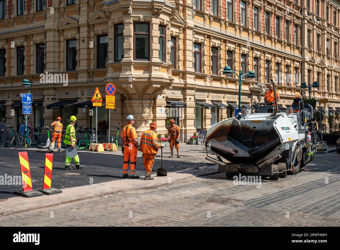 Ouvriers et machines à asphalter à l'angle de Pohjoisesplanadi et Kluuvinkatu dans le district de Kluuvi à Helsinki, en Finlande Banque D'Images