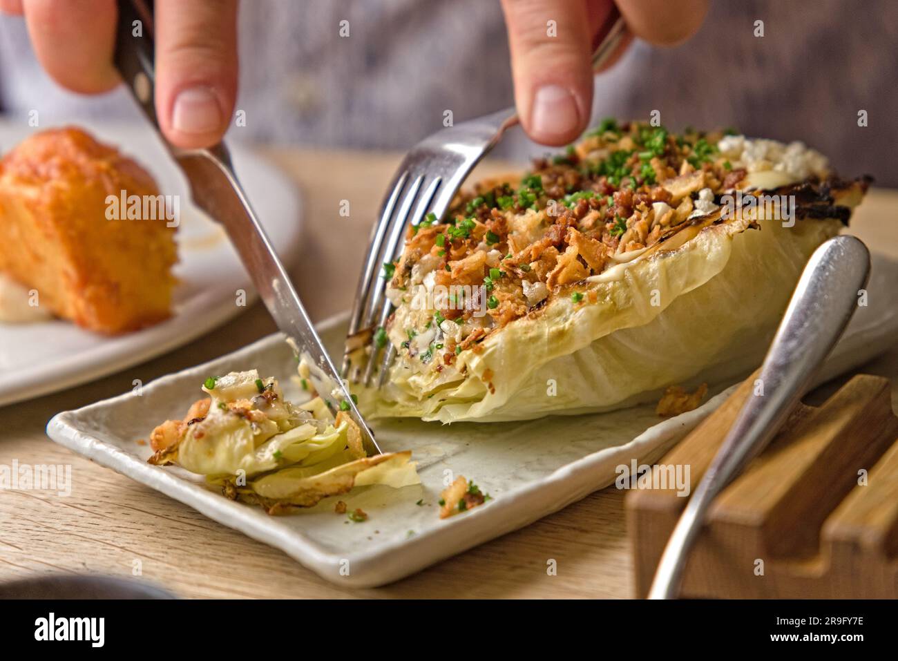 Chou hispi grillé à l'ail avec crème de salade et porc croustillant Banque D'Images