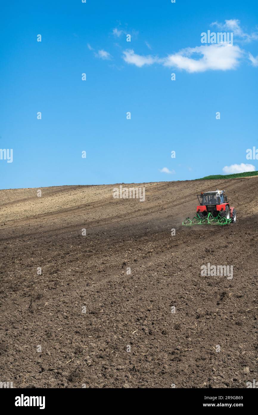 Tracteur travaillant dans les champs agricoles, paysage rural Banque D'Images