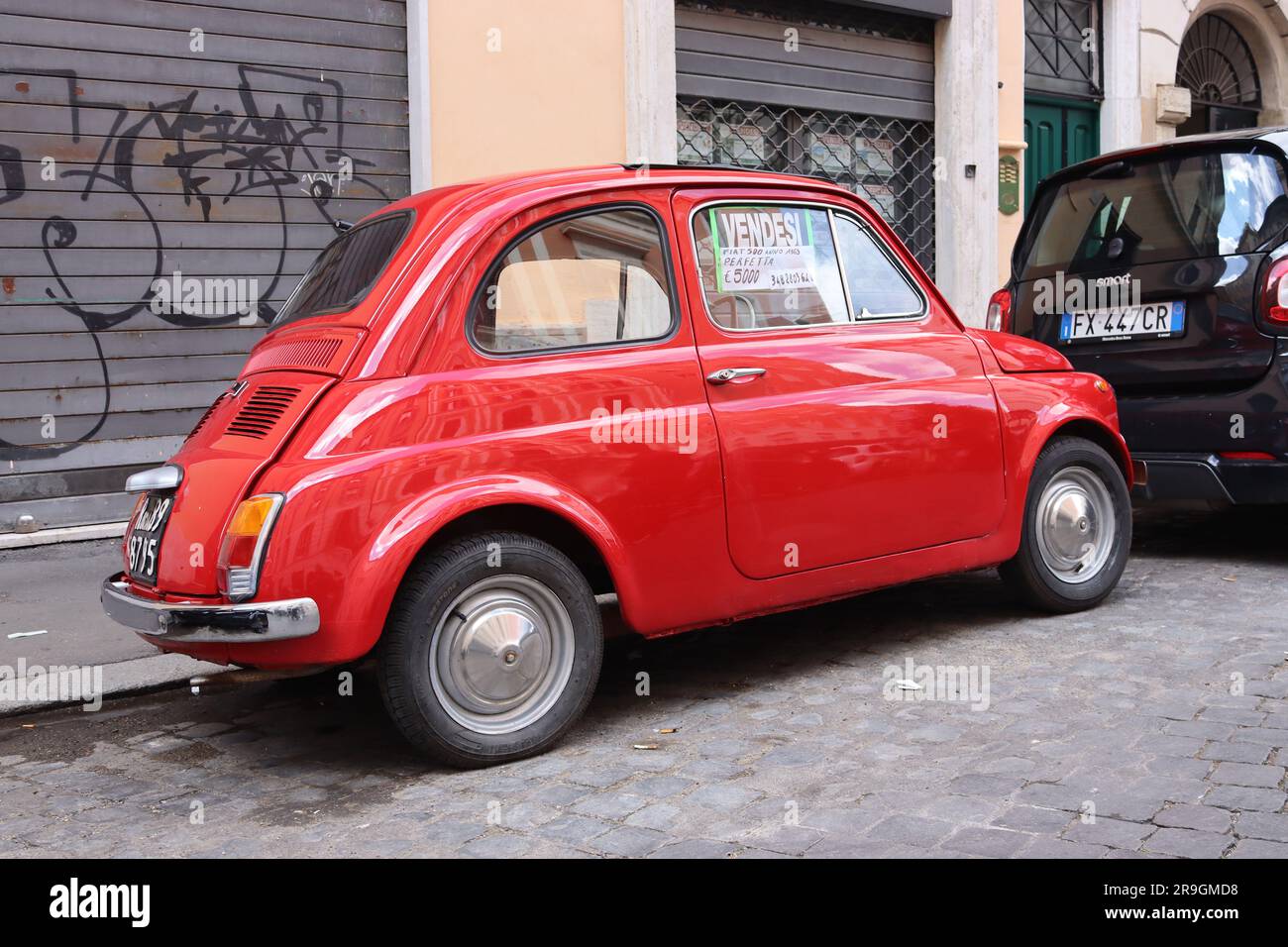 Emblématique Fiat Nuova 500 1965 entièrement restaurée et mise en vente dans l'une des rues pavées de Rome, petit argent pour une voiture culte, avril 2023. Banque D'Images