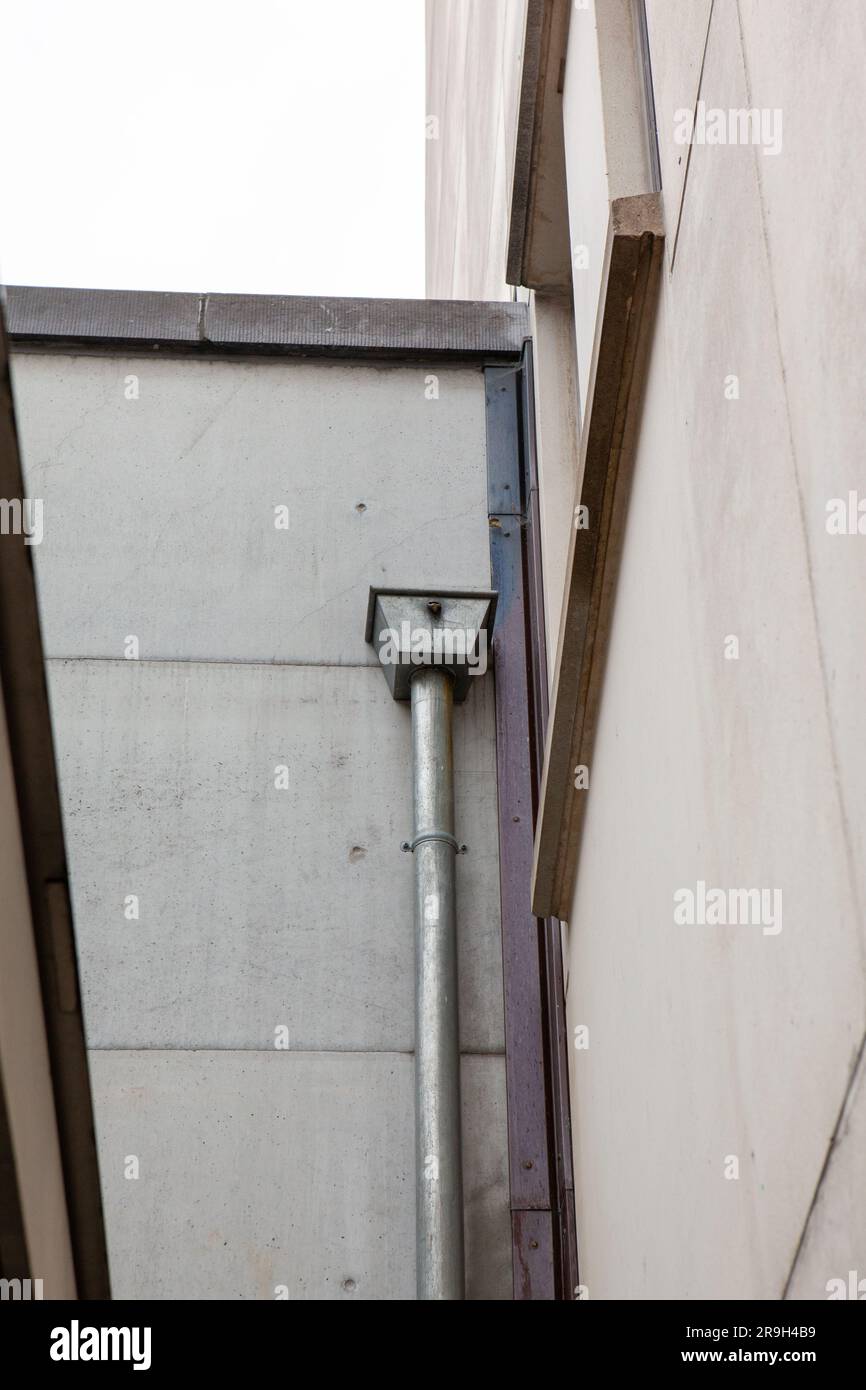 Sur un grand bâtiment de la ville, vous pouvez voir un tuyau de drainage pour l'eau de pluie sur le toit intermédiaire Banque D'Images