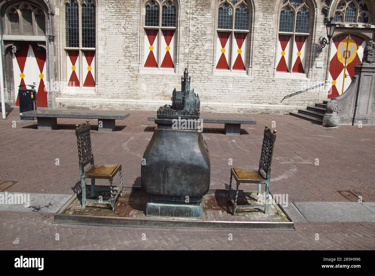 Œuvres d'art en bronze la fontaine. Un modèle de la ville de Middelburg sur une plinthe avec l'hôtel de ville gothique et deux chaises sur le Markt en face de l'hôtel de ville Banque D'Images
