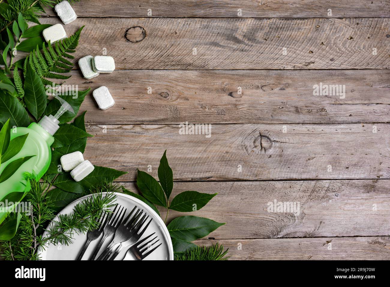 Détergent naturel pour vaisselle et capsules organiques pour lave-vaisselle. Lavage de vaisselle écologique. Bouteille de détergent à vaisselle et plaques propres sur fond de panier en bois Banque D'Images