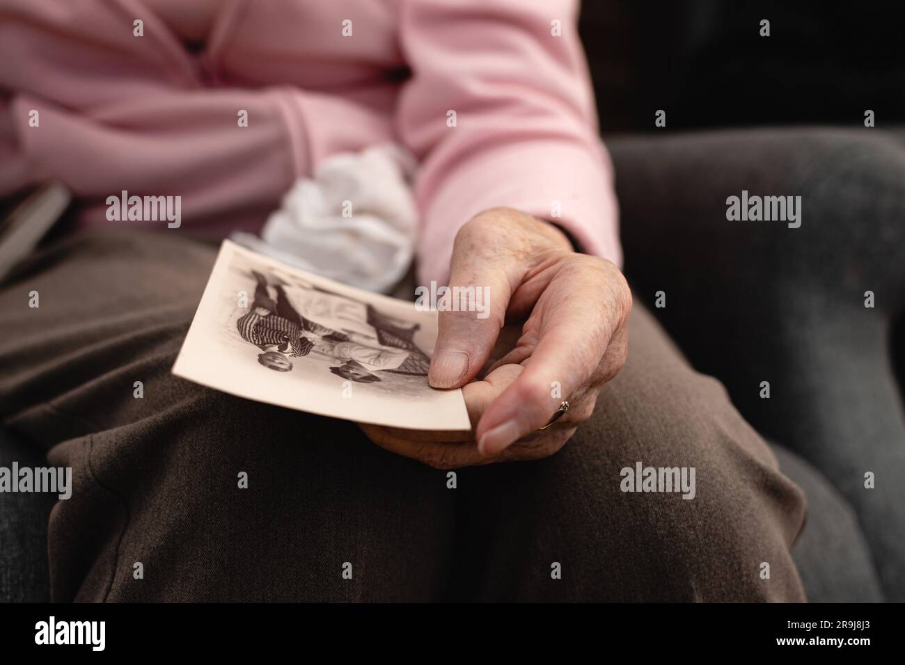 Gros plan d'une vieille personne âgée tenant une main avec une vieille photo Banque D'Images