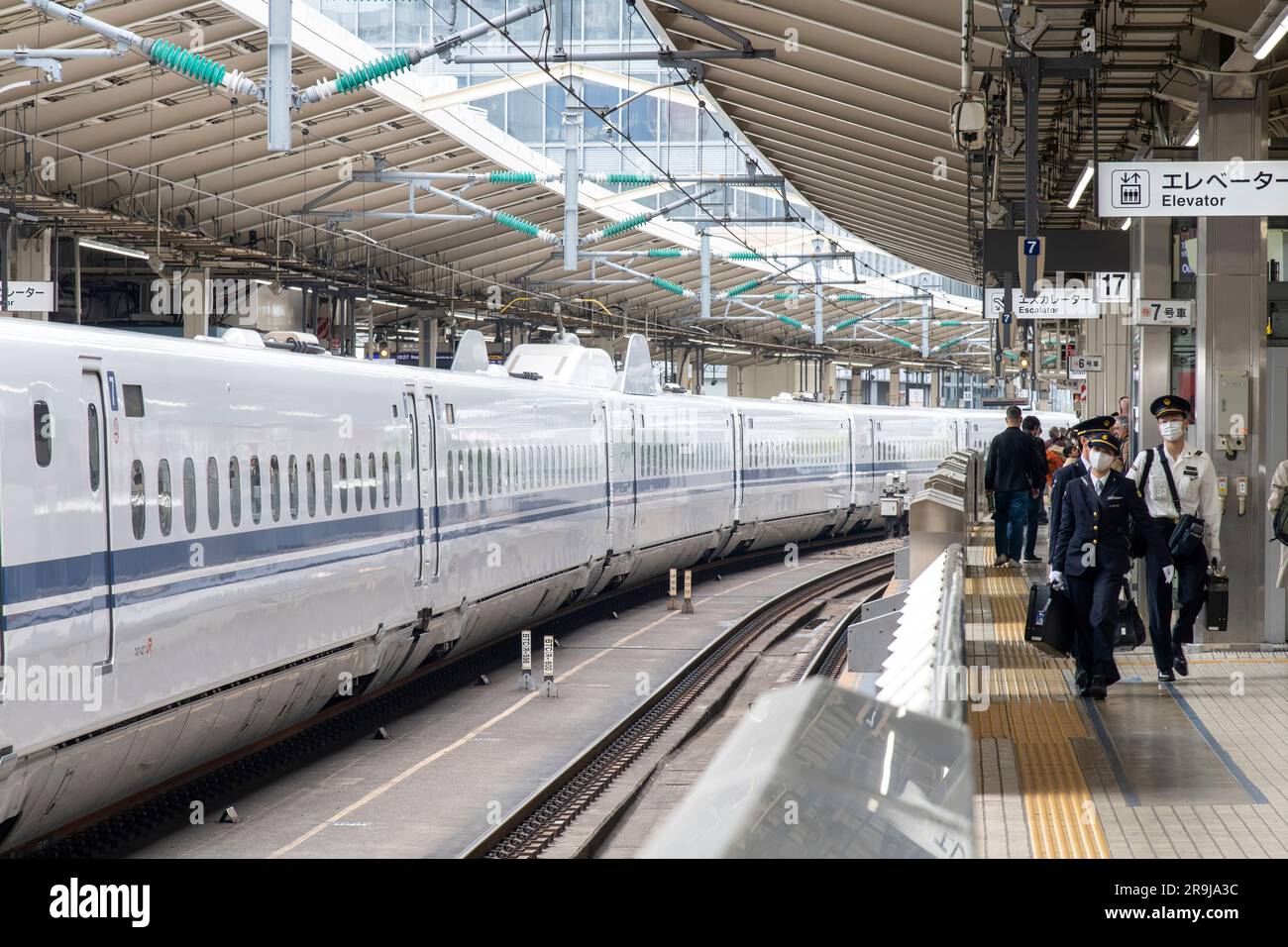 Tokyo, Japon-avril 2023 ; vue depuis l'une des plates-formes avec le nouveau personnel de train de quarts approchant et attendant le train Shinkansen sur la prochaine plate-forme Banque D'Images