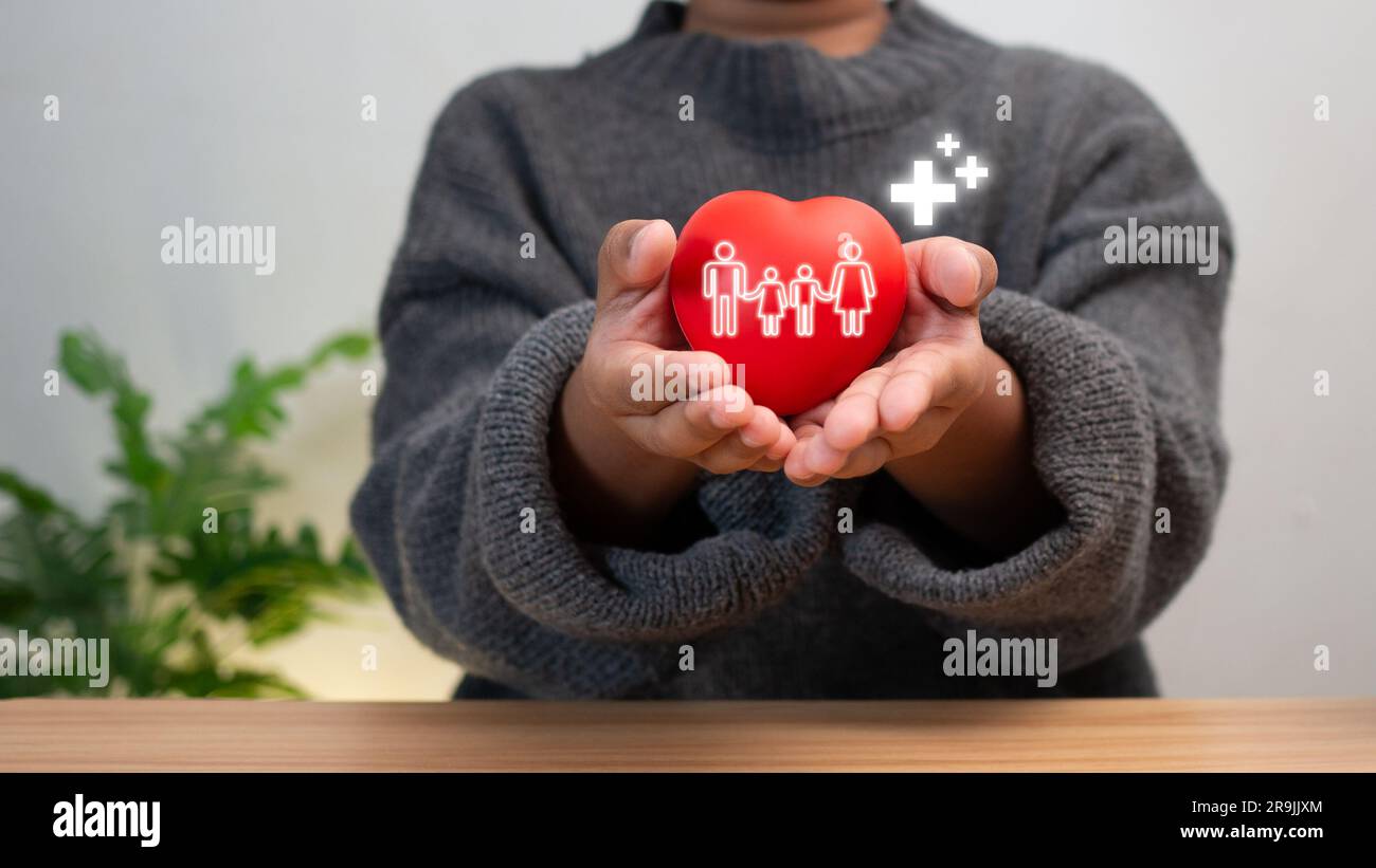 Bon concept de santé et d'assurance, concept d'assurance maladie. Main de garçon tenue plus signe et coeur rouge, volume positif. Banque D'Images