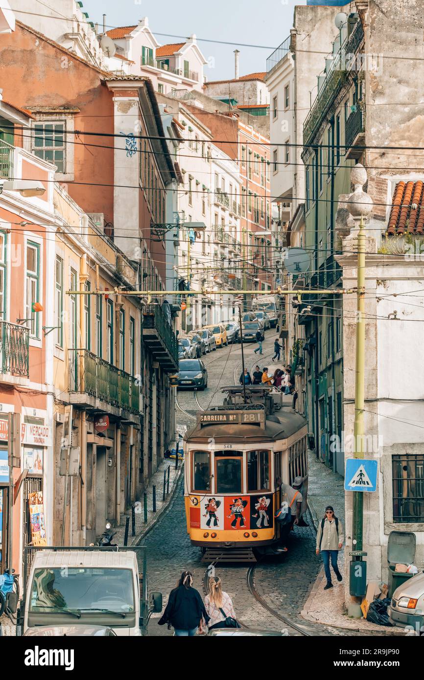 L'ancien tramway jaune dans la rue étroite de Lisbonne, Portugal. Banque D'Images