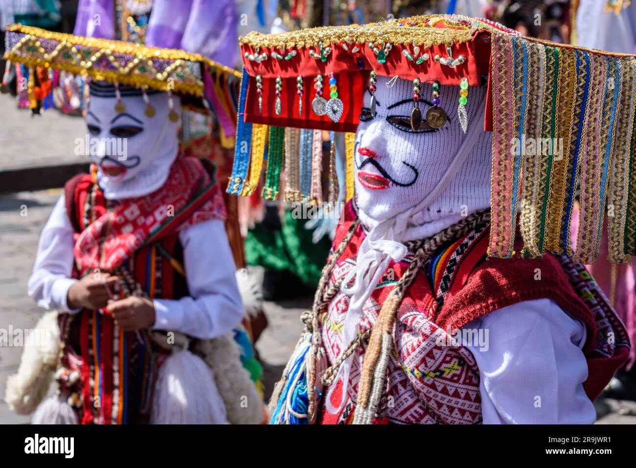 Cusco, une fête culturelle, des gens vêtus de costumes traditionnels colorés avec des masques et des chapeaux, des banderoles aux couleurs vives. Banque D'Images