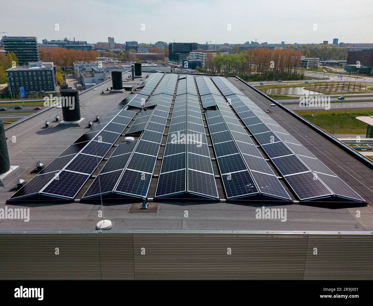 Cette vidéo de drone montre un toit de bureau avec de nombreux panneaux solaires pour l'énergie renouvelable verte. Banque D'Images