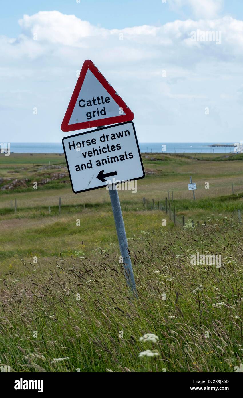 Véhicules tirés par des chevaux et panneaux routiers d'animaux près de la colonie de Vaul, île de Tiree. Banque D'Images