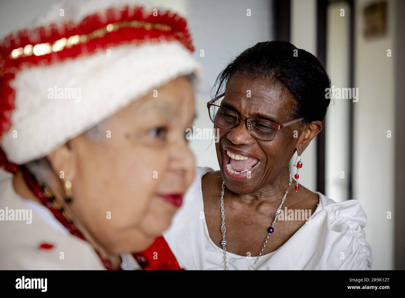 AMSTERDAM - Shirley lors de la mise en place à la grand-mère Rinia Overman (r) du koto, un vêtement traditionnel de femmes créoles au Suriname, à l'approche de Keti Koti. Le 1 juillet, il y aura 160 ans que les pays-Bas décidèrent d'abolir l'esclavage et il y a 150 ans que les derniers réduits en esclavage seront libérés. ANP ROBIN VAN LONKHUIJSEN pays-bas sortie - belgique sortie Banque D'Images