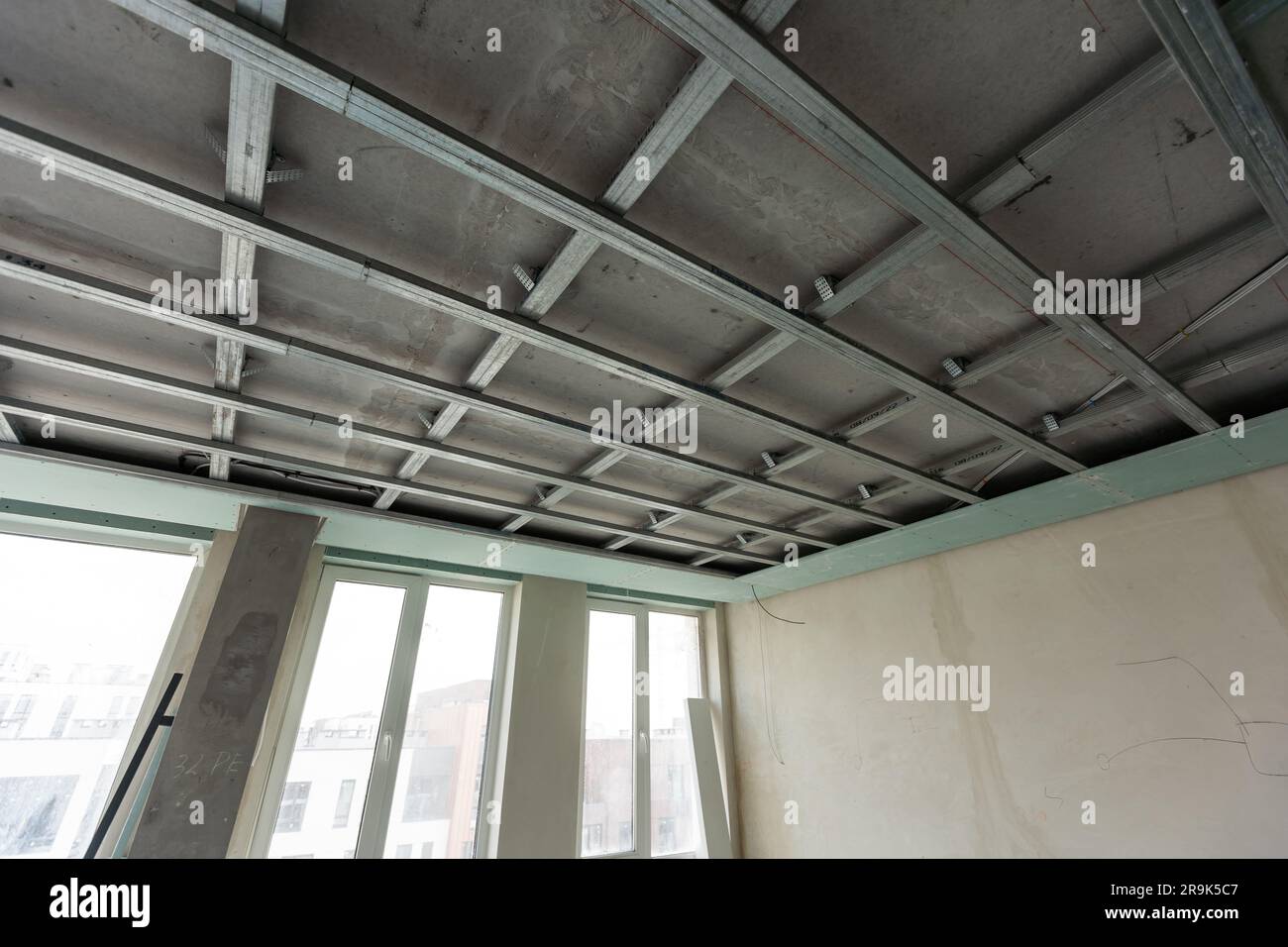 Les travailleurs installent des plaques de plâtre (cloisons sèches) pour les murs de gypse dans l'appartement est en construction, remodelage, rénovation, extension, restauration et Banque D'Images