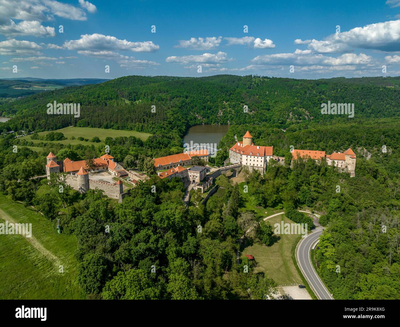 Vue aérienne du château de Veveri en Moravie avec de grandes cours, plusieurs portes, tours carrées et rondes avec ciel bleu nuageux Banque D'Images