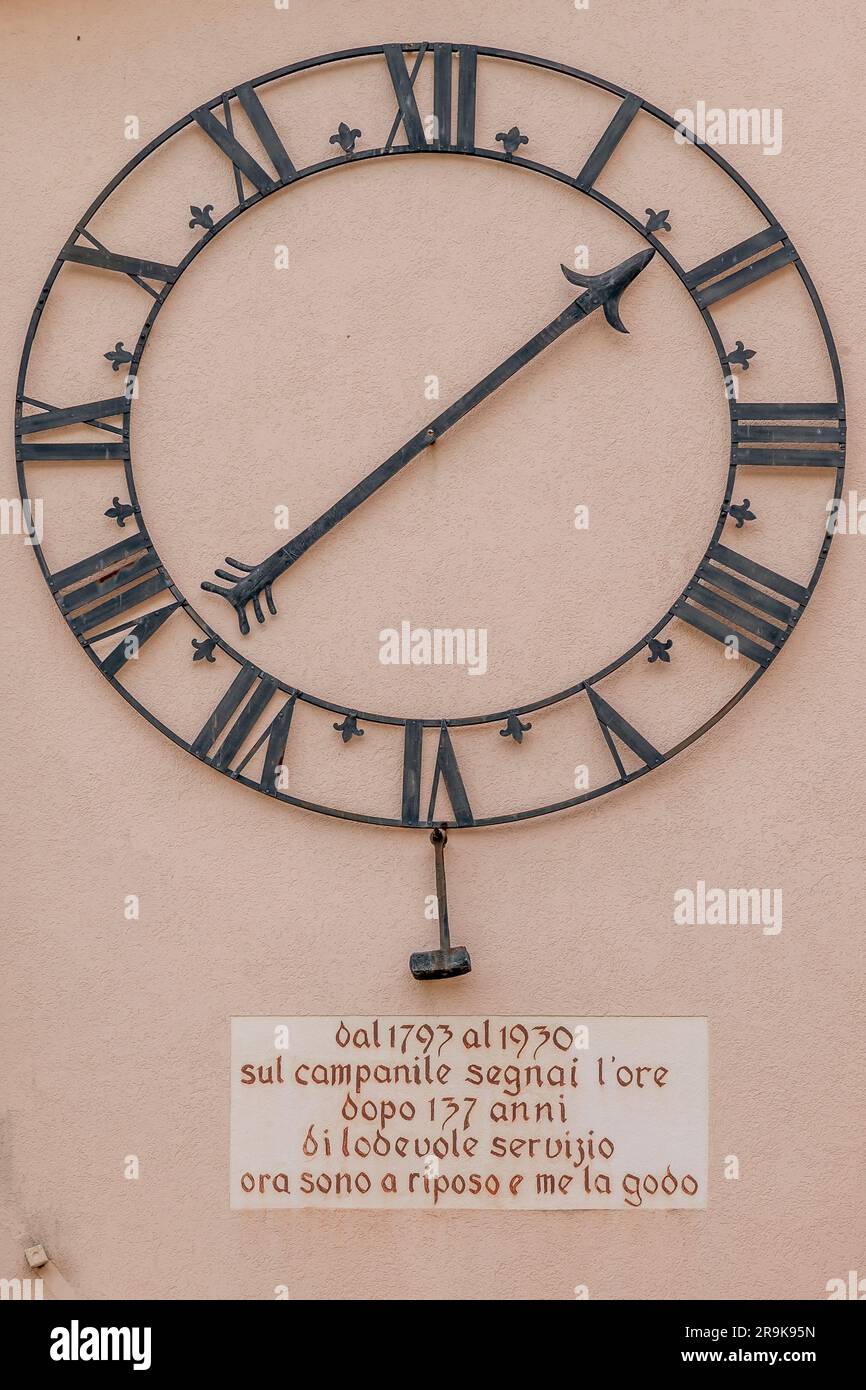 L'ancienne horloge du clocher de Caslano, en Suisse, attachée au mur d'un bâtiment du centre, après avoir été désaffectée Banque D'Images