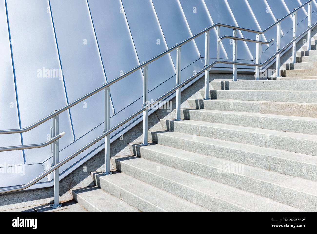 Arrière-plan abstrait d'architecture moderne avec un escalier qui remonte près d'un toit en métal gris brillant Banque D'Images