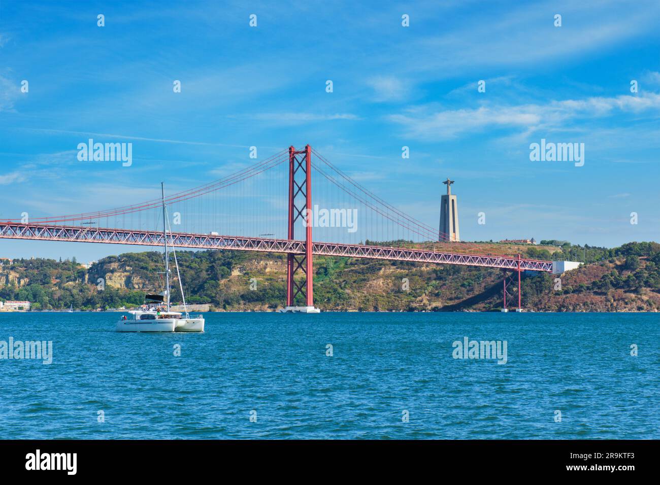 Vue sur le pont 25 de Abril au-dessus du Tage, le monument Christ le Roi et un yacht. Lisbonne, Portugal Banque D'Images