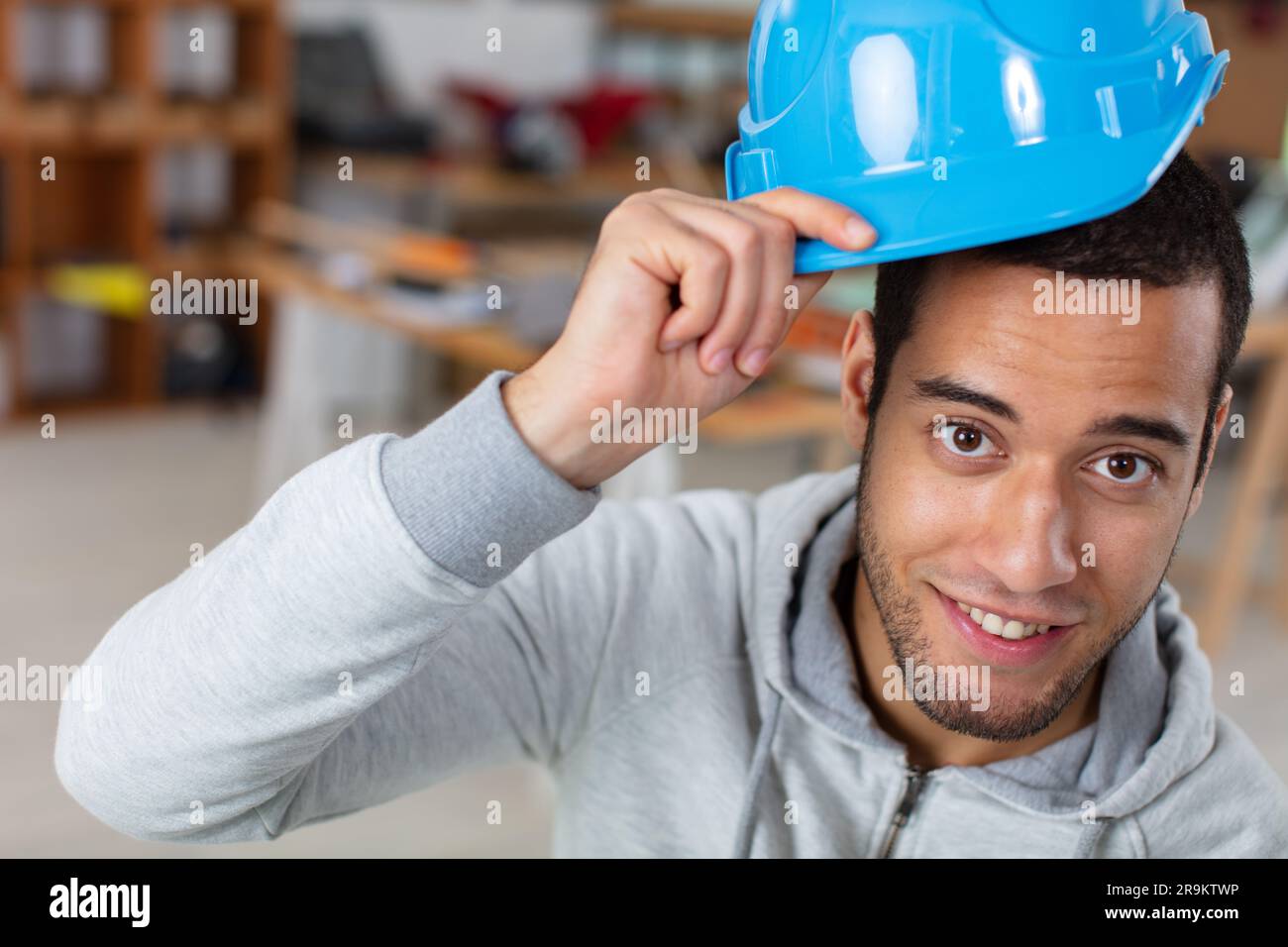 un constructeur respectueux touchant le casque de sécurité à l'accueil Banque D'Images