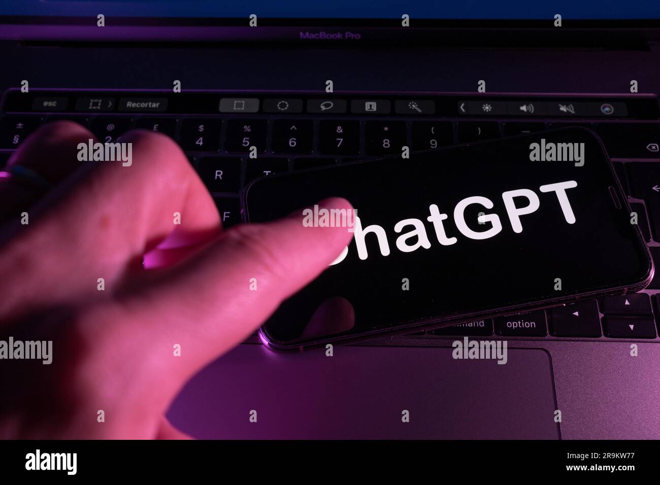 Açores, Portugal - 21.01.2023 : smartphone sur le dessus du clavier d'ordinateur portable avec ChatGPT mot sur l'écran et doigt d'homme le touchant. Développé par OpenAI. Banque D'Images