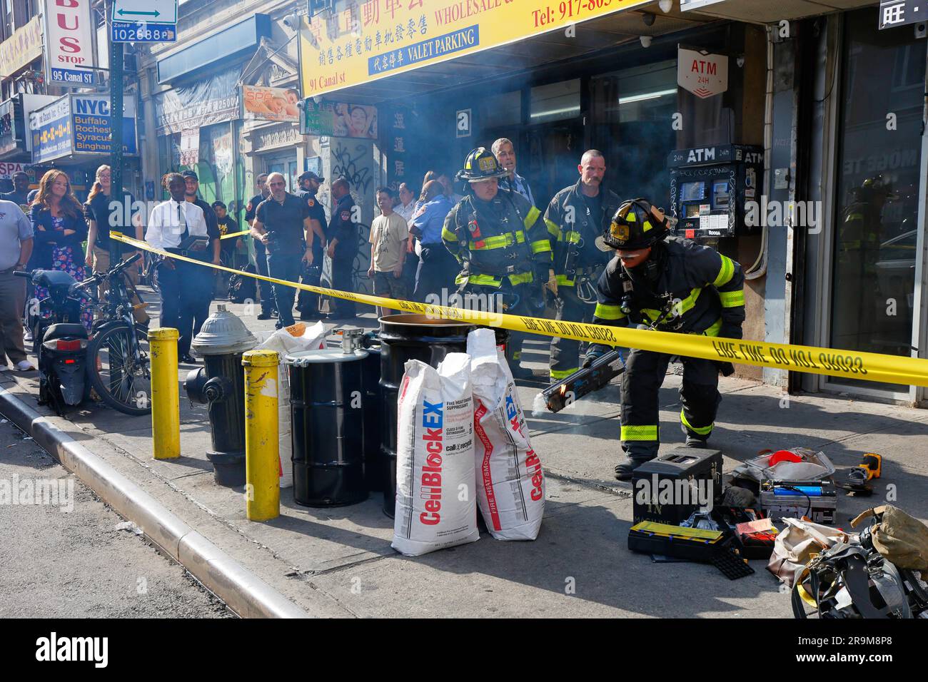 New York, États-Unis, 27 juin 2023, FDNY les pompiers inspectent un atelier de réparation de vélos électroniques dans le quartier chinois de Manhattan à la recherche de batteries Li-ion défectueuses et dangereuses. Photo : Laura Kavanagh, commissaire aux incendies de New York, et d'autres responsables de la ville (à gauche), observez les pompiers jeter une batterie de vélo électrique au lithium-ion qui a été percée accidentellement lors de la mise au rebut, provoquant un court-circuit et un incendie. Les décès récents causés par l'incendie de 20 juin dans une boutique de vélos en ligne de Madison St--en plus des nombreux autres incendies cette année imputables à des batteries de vélos électriques dans toute la ville--ont poussé la ville vers une mise en application accrue. Banque D'Images