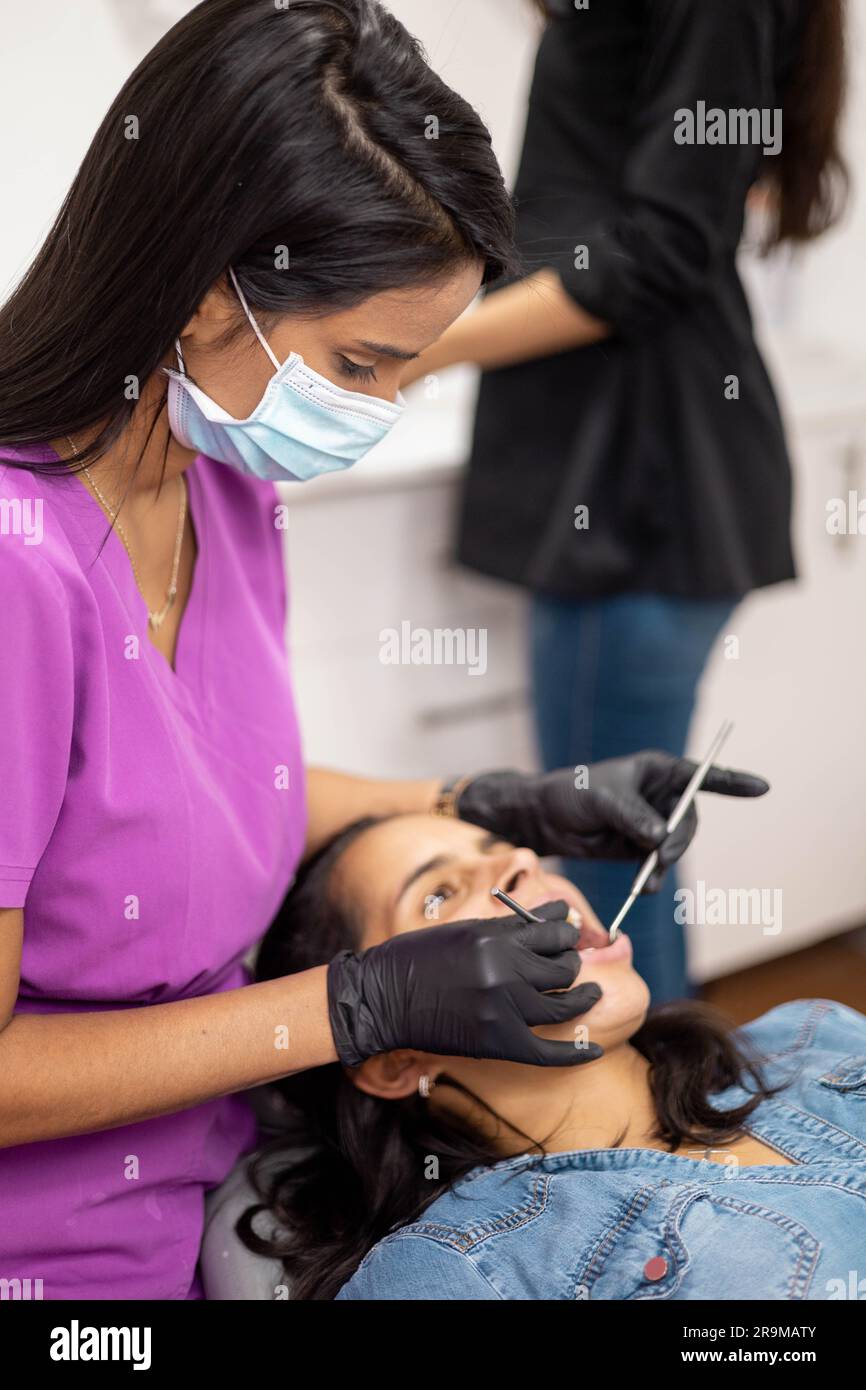 équipement dentaire et mode de vie professionnel de la santé au travail, femme portant des protections, dentiste effectuant un traitement oral au patient Banque D'Images