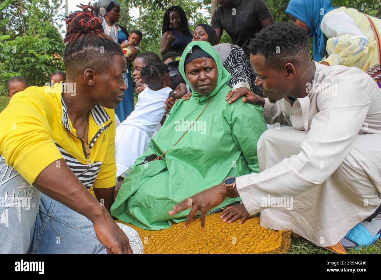 Namata Mariam, au centre, est entourée de ses neuf enfants et de neuf petits-enfants sur Eid al-Fitr, une fête musulmane qui marque la fin du ramadan, à Kampala, en Ouganda, sur 21 avril 2023. (Nakisanze Segawa/Global Press Journal) Banque D'Images