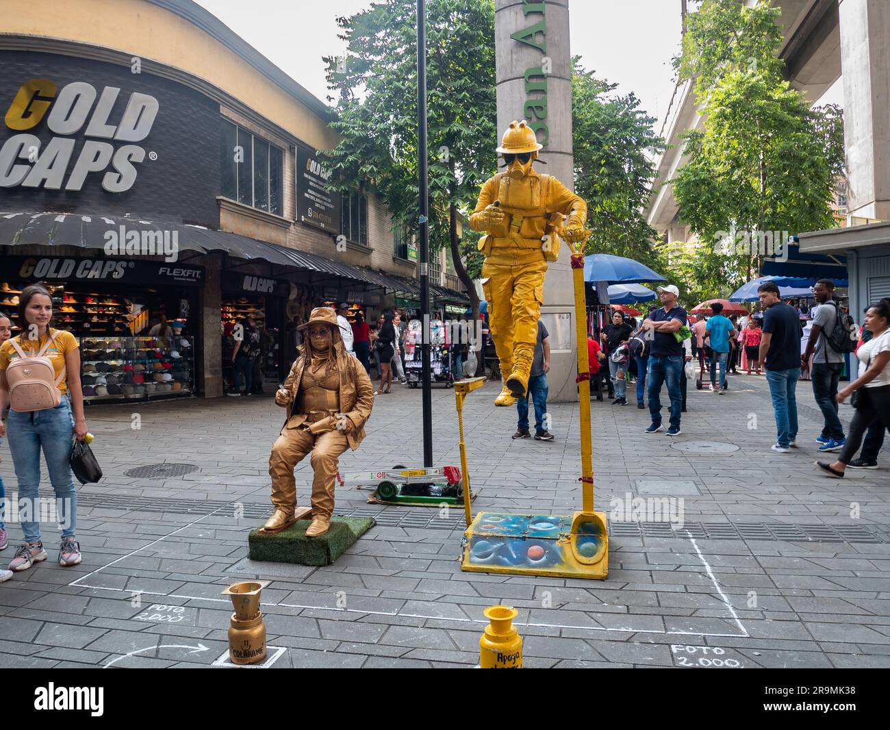 Medellin, Antioquia, Colombie -21 novembre 2022: Représentation par des artistes de rue, une femme couverte d'or, portant un chapeau et des lunettes et un homme dans un plein Banque D'Images