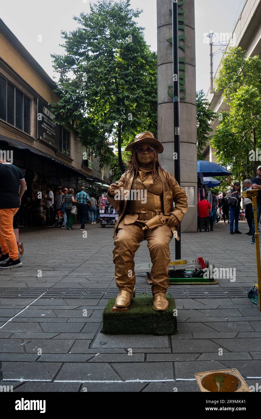 Medellin, Antioquia, Colombie -21 novembre 2022: Représentation d'artistes de rue, une femme couverte d'or, portant un chapeau et des lunettes près de la Sta du métro Banque D'Images